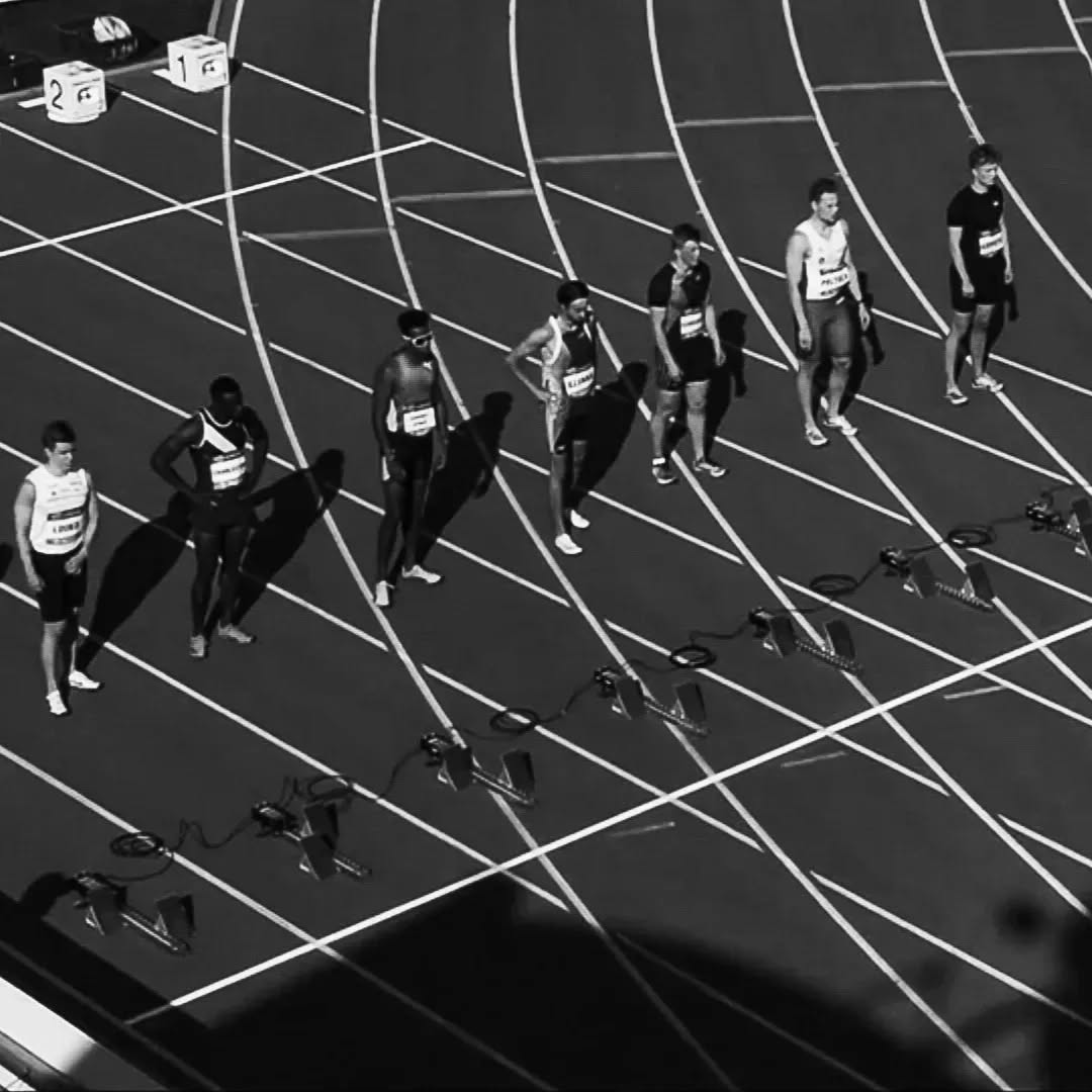 Juoksijat lähtötelineissä mustavalkokuvassa